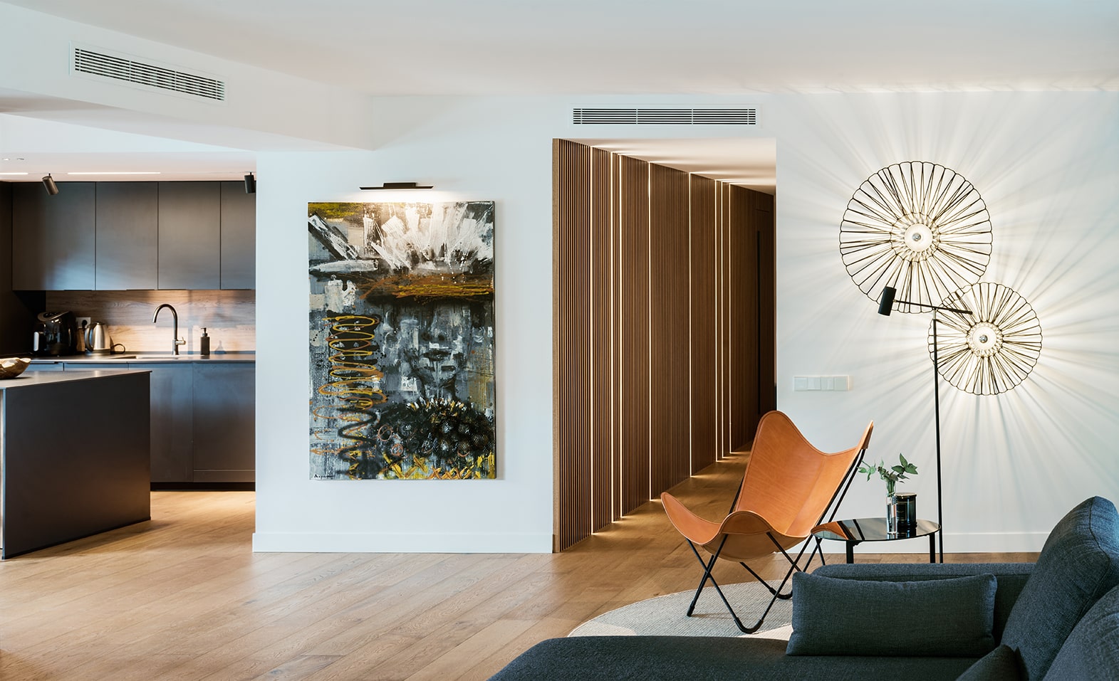 Vista general del salón y la cocina con el detalle del cuadro del piso en Sant Cugat del Vallés