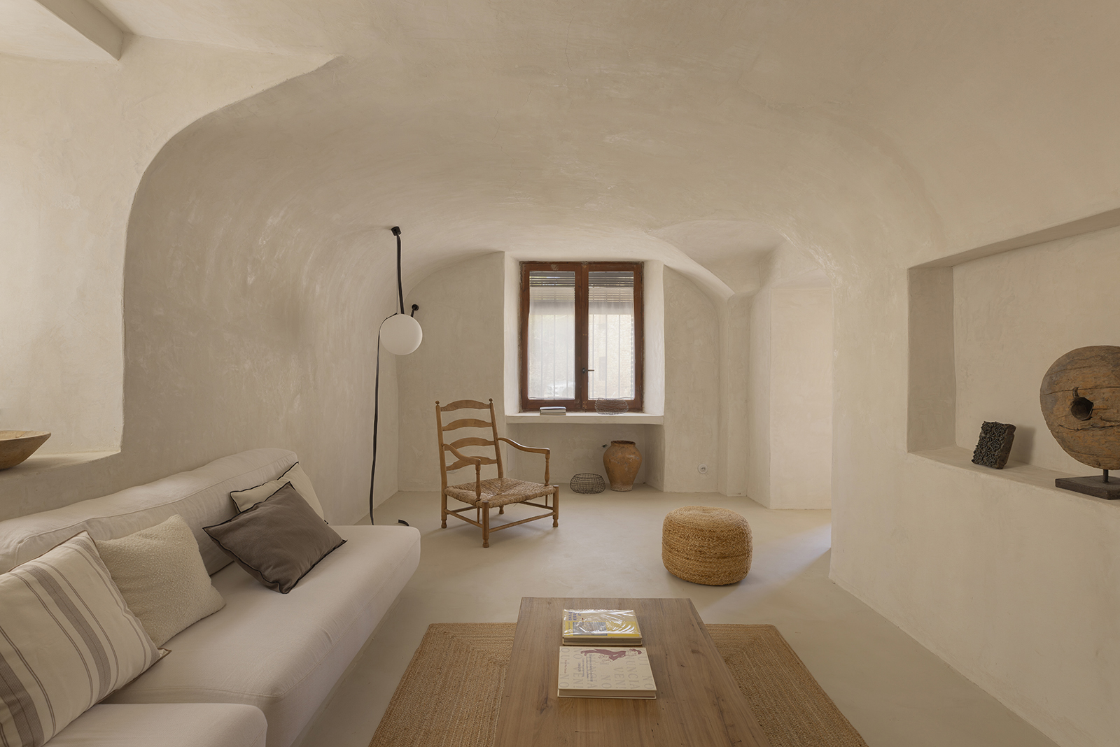 recuperar-la-calma-sala-estar-voltada-casa-historica Sala d’estar amb sostre voltat en una casa històrica reformada amb un interiorisme serè