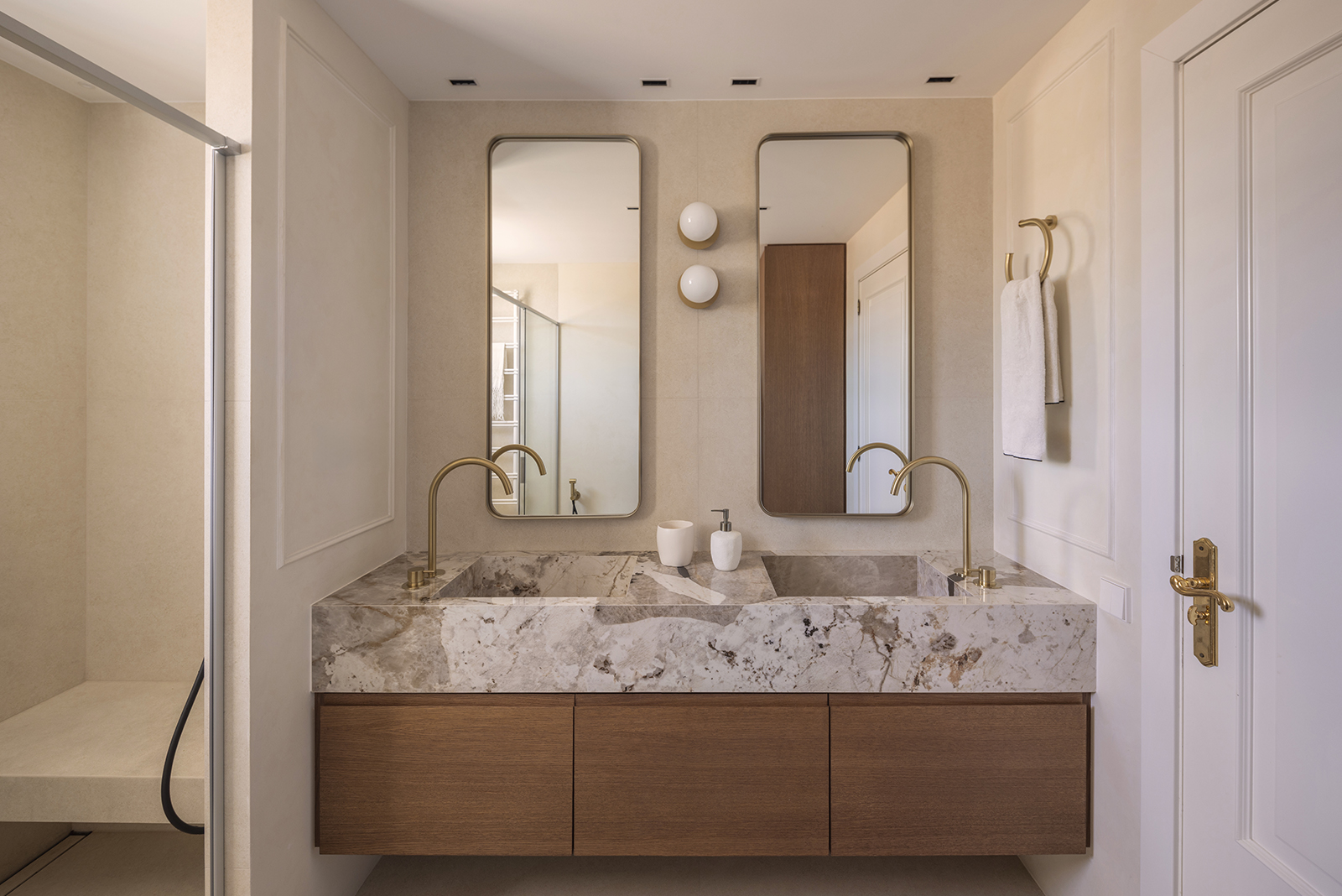 Baño con grifería de latón cepillado y doble lavabo Baño con grifería de latón cepillado y doble lavabo