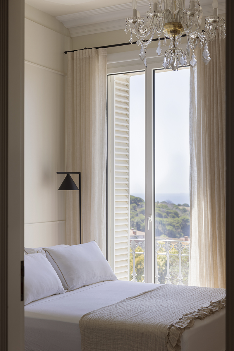 Dormitorio luminoso con cortinas de lino y vistas al exterior Dormitorio luminoso con cortinas de lino y vistas al exterior